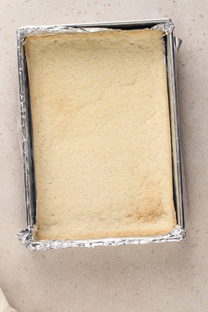 Baked shortbread crust in a foil-lined pan.