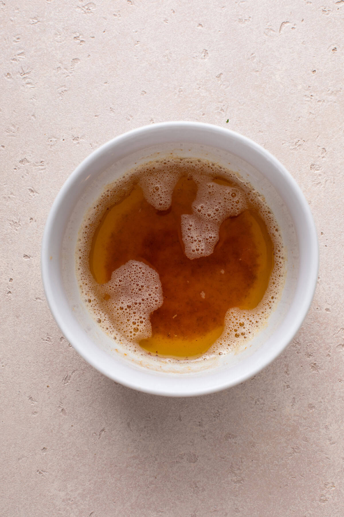 Browned butter in a white bowl.