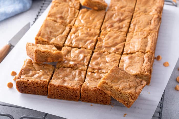 Sliced brown butter blondies on a piece of parchment paper.