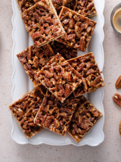 Pecan bars arranged on a white platter.