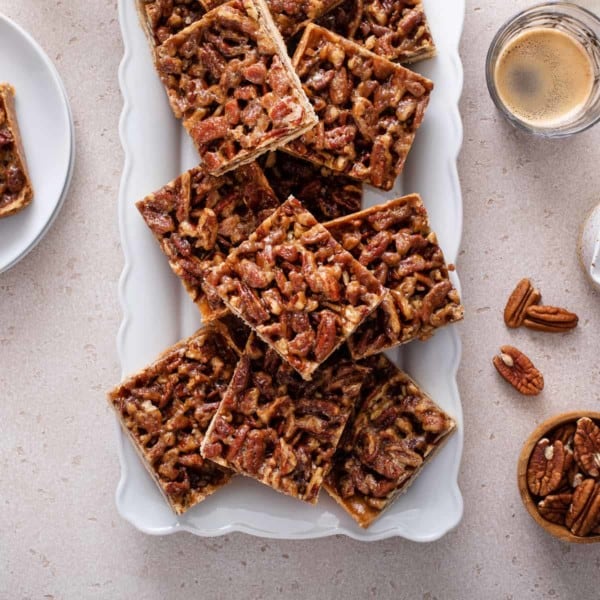 Pecan bars arranged on a white platter.