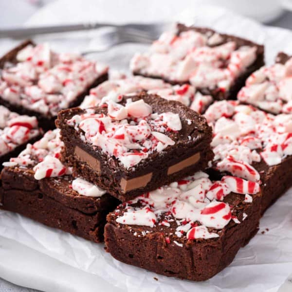 Sliced peppermint brownie set on top of a sliced pan of peppermint brownies.