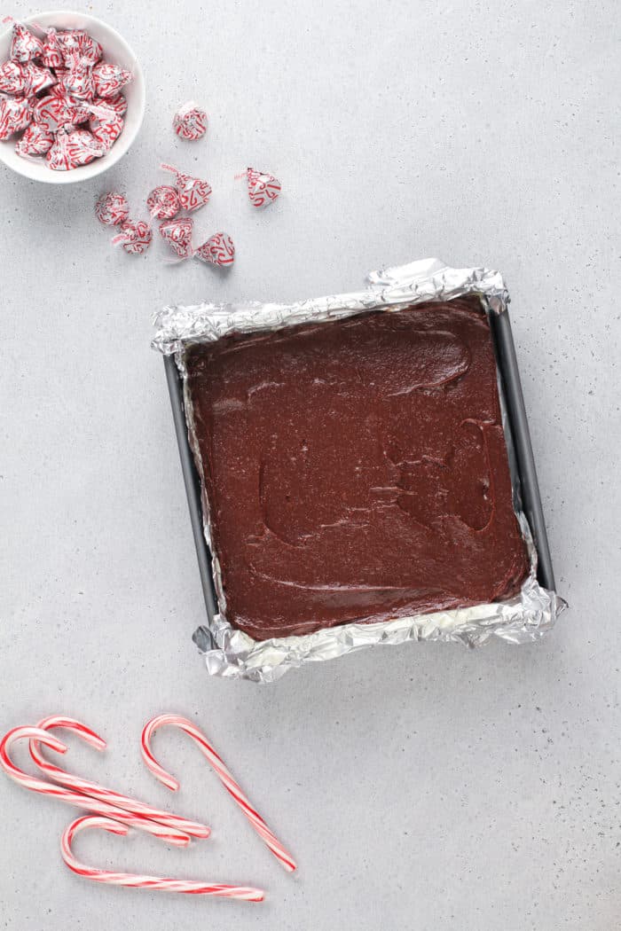 Unbaked peppermint brownies in a foil-lined pan, ready to go in the oven.