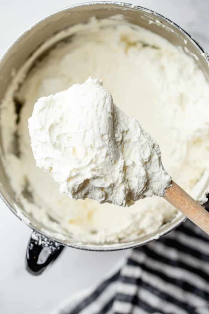 Homemade buttercream frosting in a mixing bowl with a rubber spatula ready to be put in a piping bag