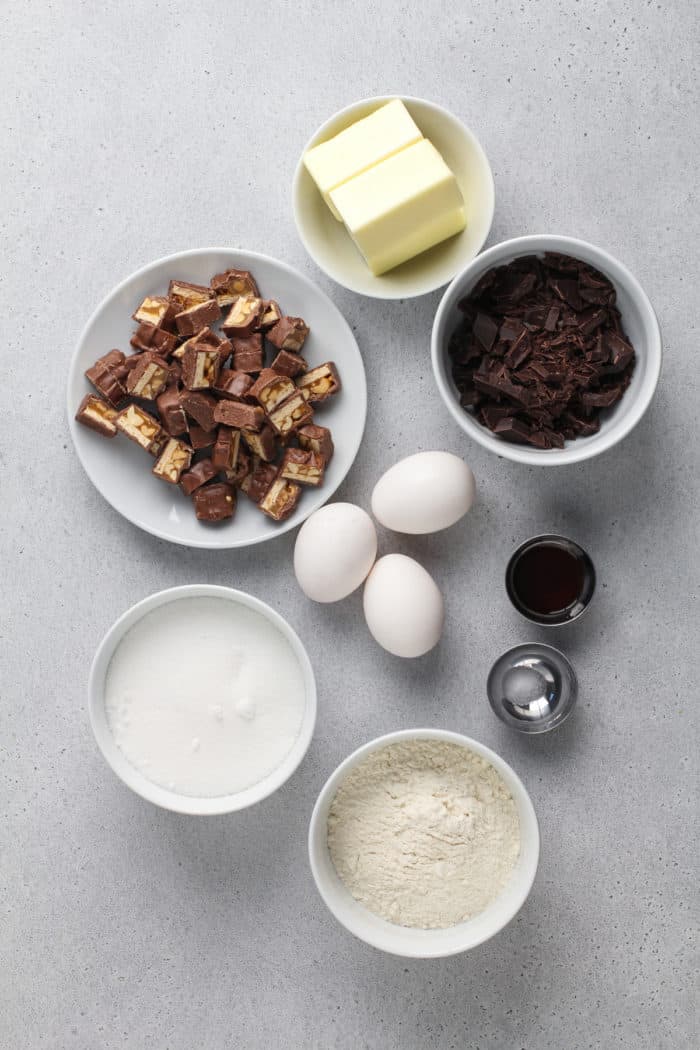 Snickers brownie ingredients arranged on a gray countertop.
