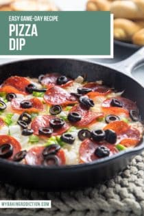Pizza dip topped with pepperoni, olives, onions, and green peppers in a cast iron skillet on a beige trivet. Text overlay includes recipe name.