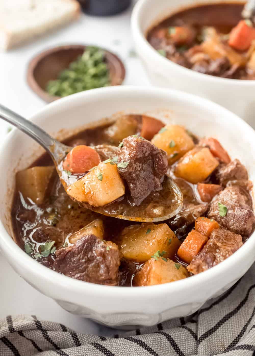 Close up of a spoonful of Guinness stew over a white bowl