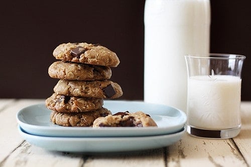 Stack of almond cookies on a plate next to a glass of milk