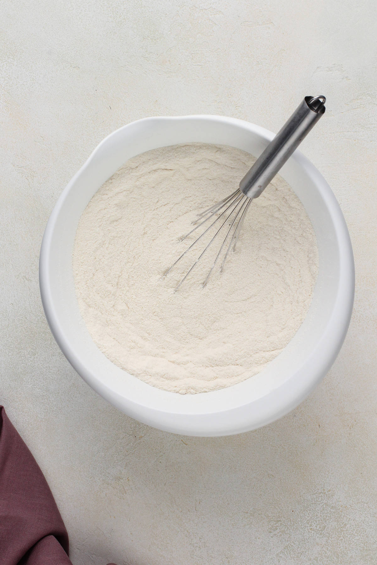 Dry ingredients for chocolate guinness cake whisked together in a white bowl.