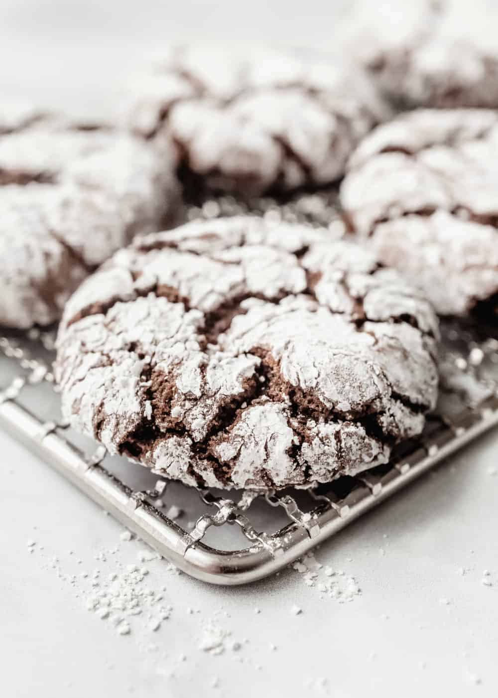 Close up view of a chocolate crinkle cookie on a cooling rack