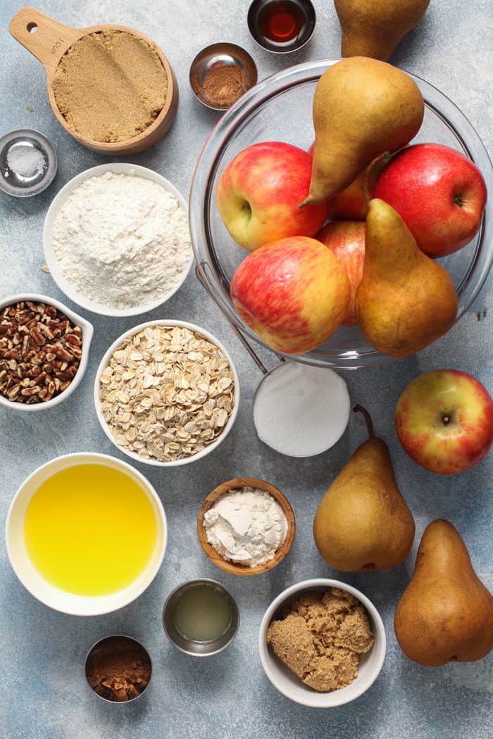 Ingredients for apple pear crisp on a blue countertop