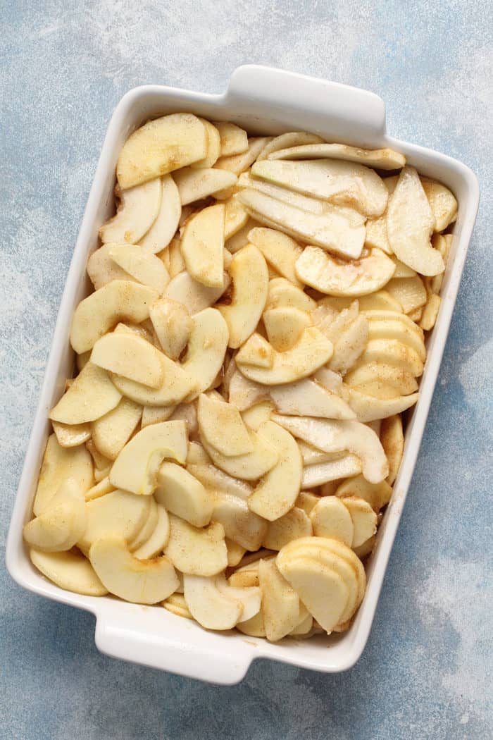 Filling for apple pear crisp in a white baking dish, set on a blue countertop