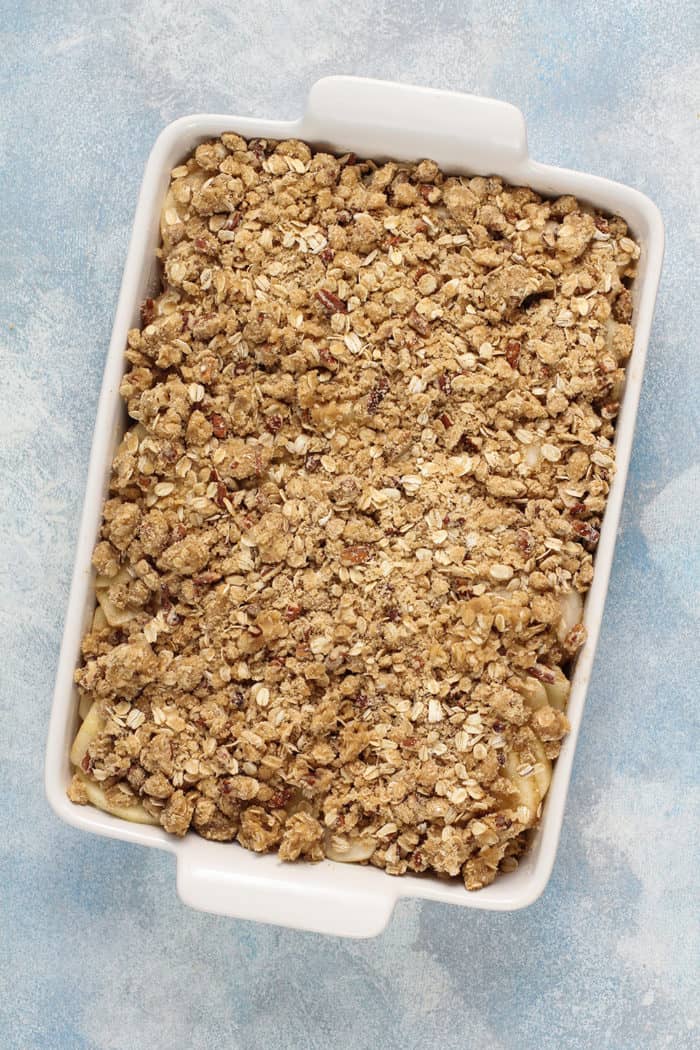 Apple pear crisp in a white baking dish, ready to be baked