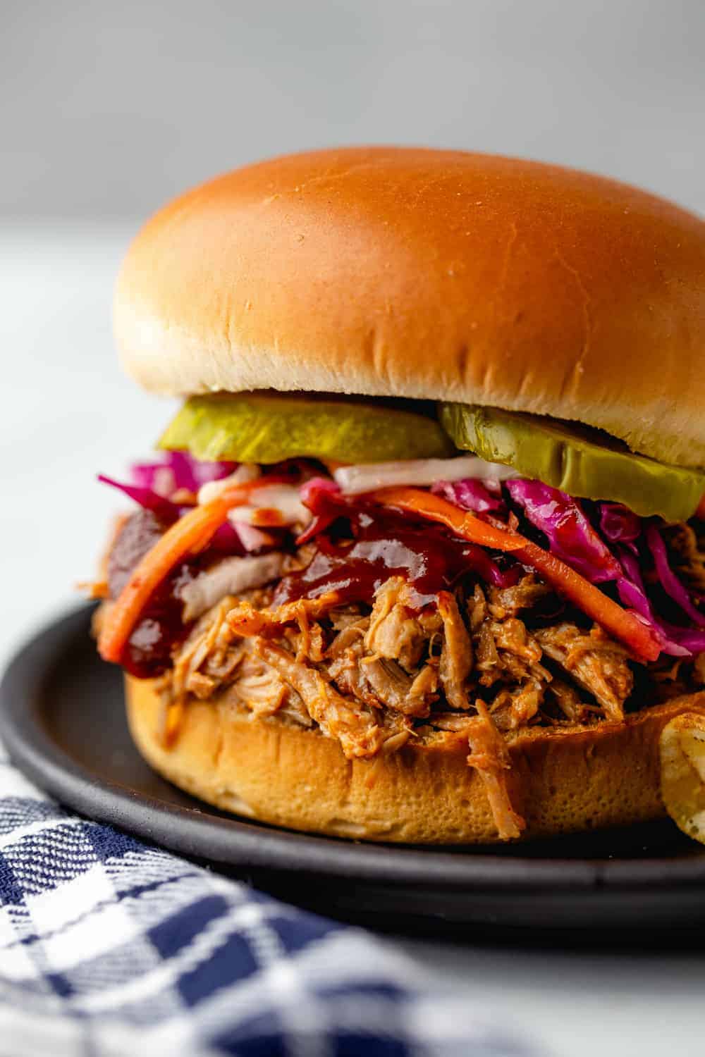 Easy Crockpot Pulled Pork is as easy as can be. Top with slaw and pickles for the perfect sandwich.