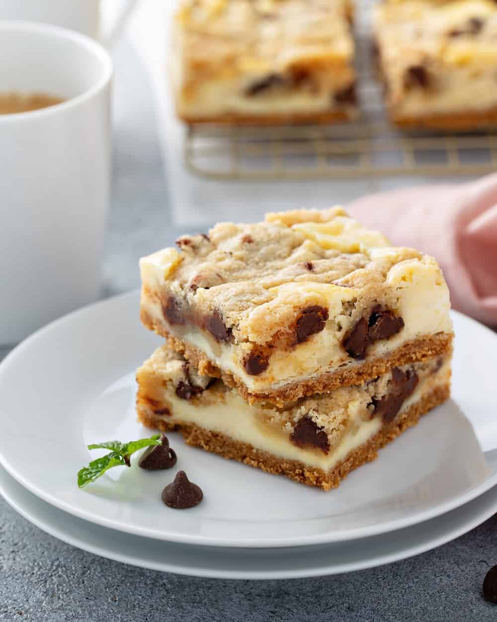 Two cookie dough cheesecake bars on a white plate