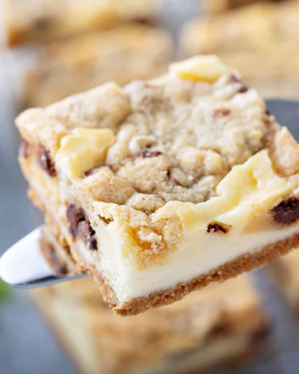 Knife lifting up a piece of cookie dough cheesecake bar