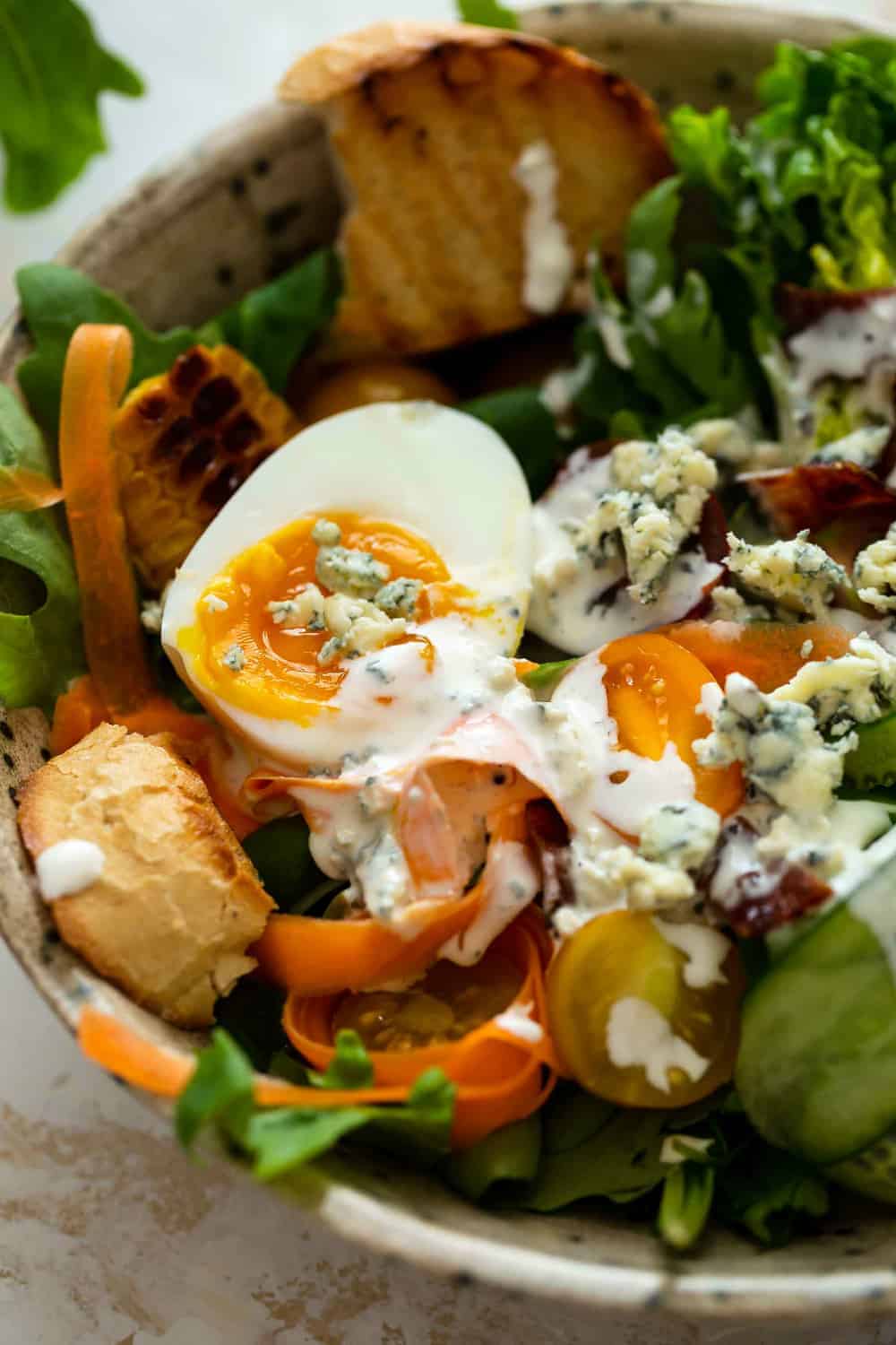 Salad dressed with homemade blue cheese dressing and blue cheese crumbles