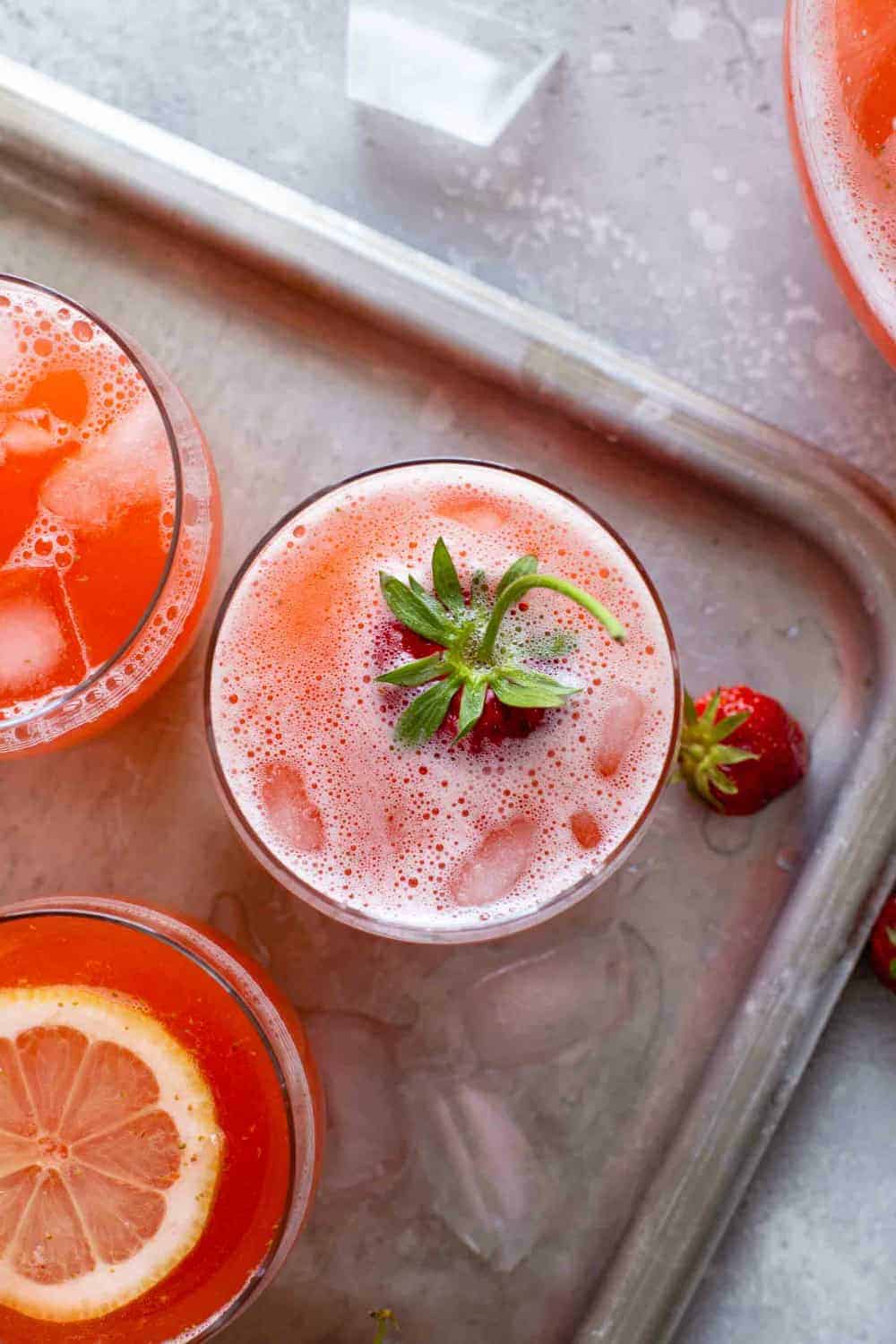 Overhead view of glasses of strawberry lemonade on a sheet tray