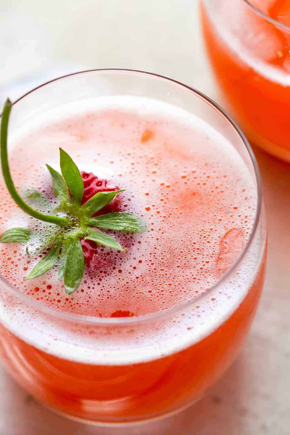 Close-up view of strawberry lemonade garnished with a whole strawberry