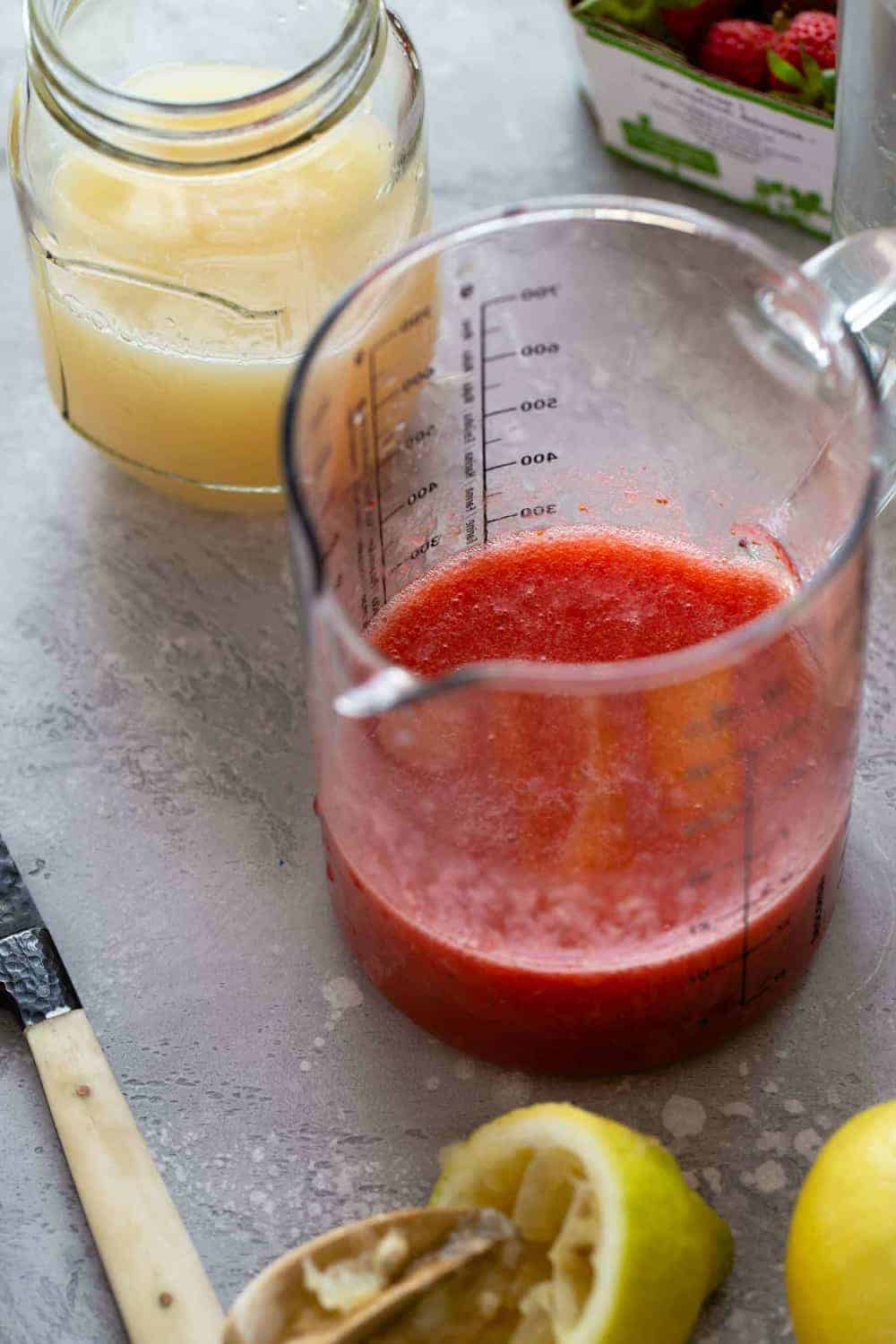 Strawberry puree and lemon juice in measuring cups