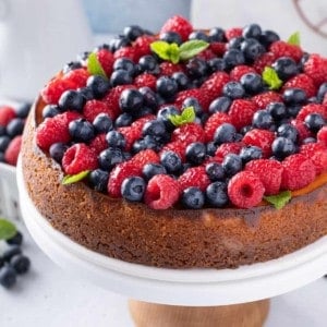 Ricotta cheesecake topped with rows of red and blue berries.