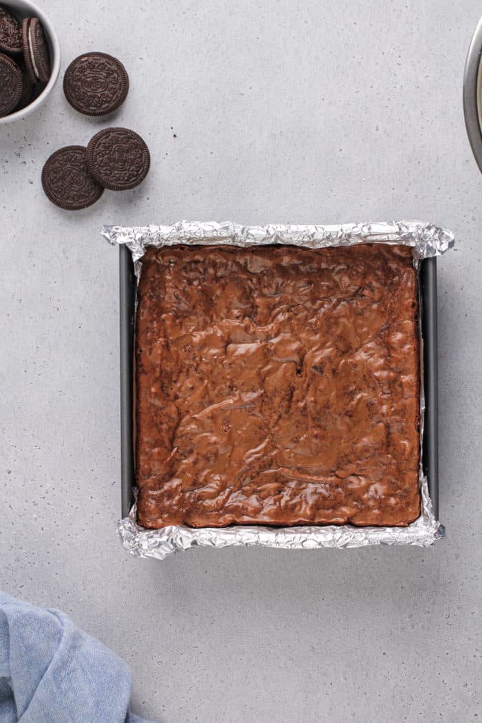 Baked pan of oreo brownies cooling on a gray countertop.