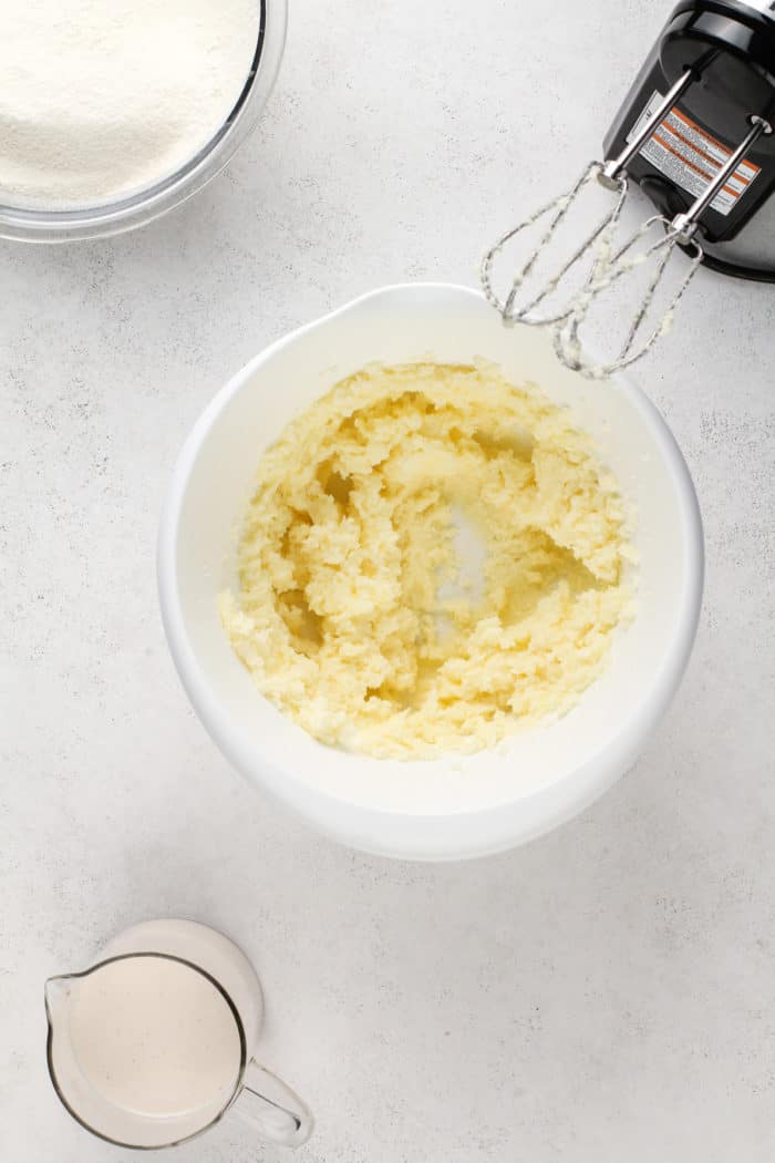 Butter and sugar creamed together in a white mixing bowl.