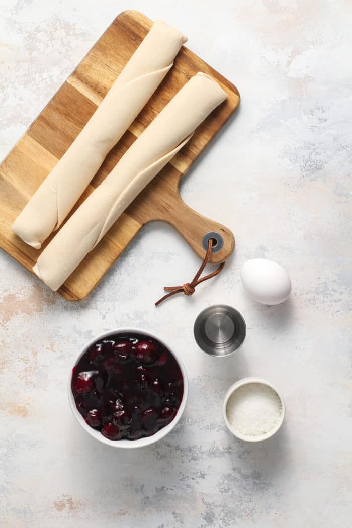 Ingredients for cherry hand pies arranged on a light countertop