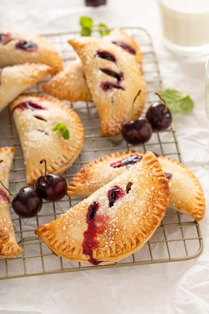 Cherry hand pies arranged on a wire cooling rack