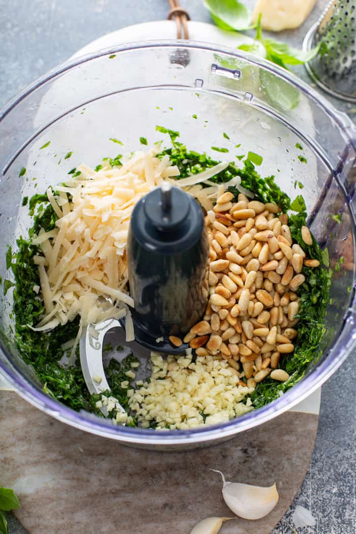 Ingredients for fresh basil pesto in the bowl of a food processor