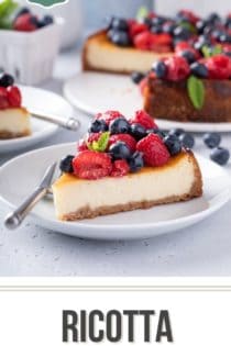 White plate with a slice of ricotta cheesecake that is topped with rows of raspberries and blueberries. Text overlay includes recipe name.