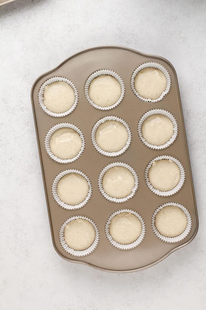 Vanilla cupcake batter in a cupcake pan, ready to go in the oven.