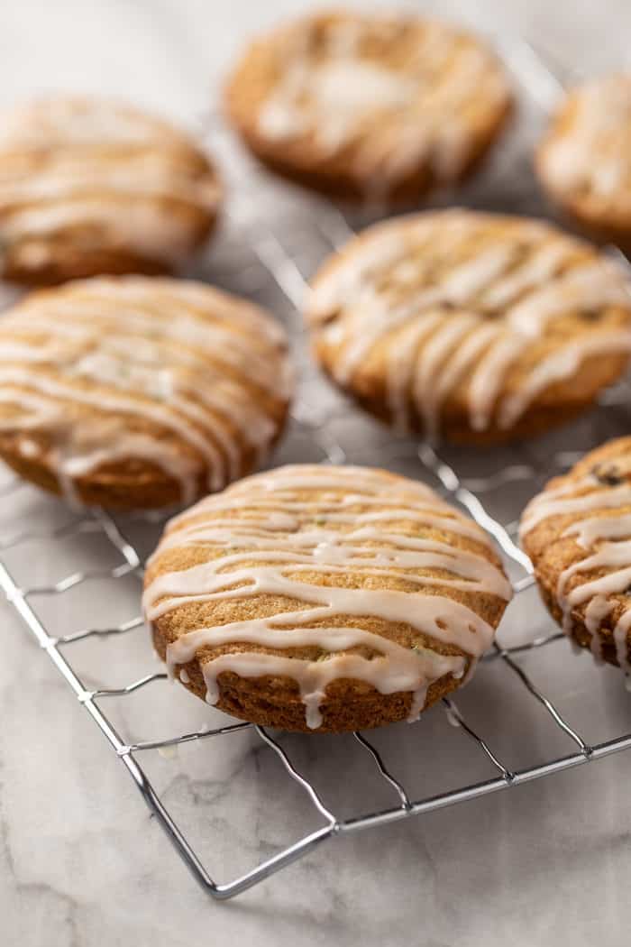 Glazed zucchini cookies set on a wire rack on a marble countertop