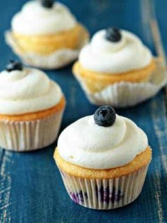 Blueberry cheesecake cupcakes on a wooden surface