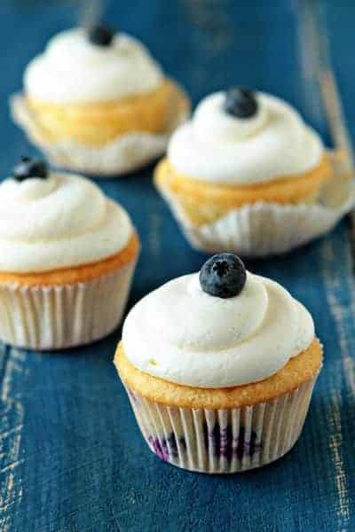 Blueberry cheesecake cupcakes on a wooden surface
