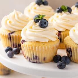 Cupcakes aux framboises sur une assiette à gâteau blanche.
