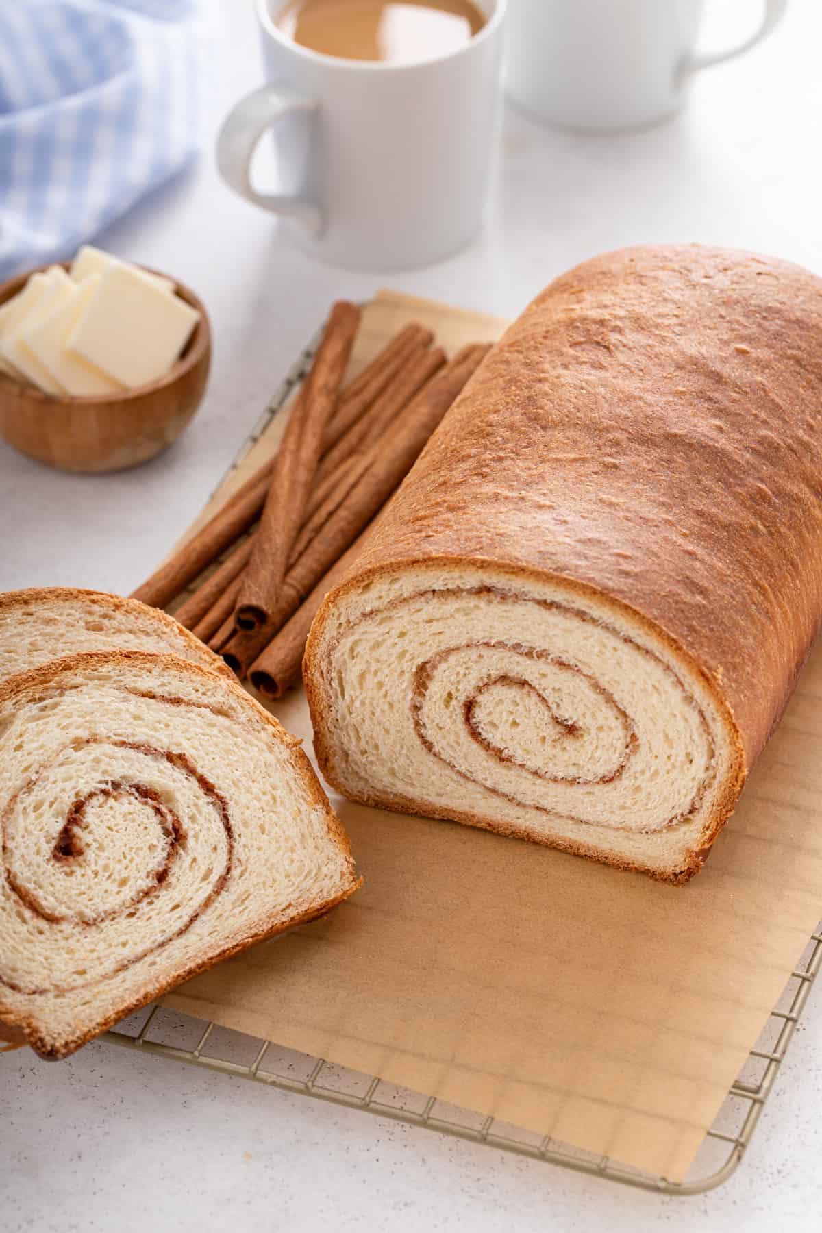 Sliced loaf of cinnamon swirl bread on a piece of parchment paper.
