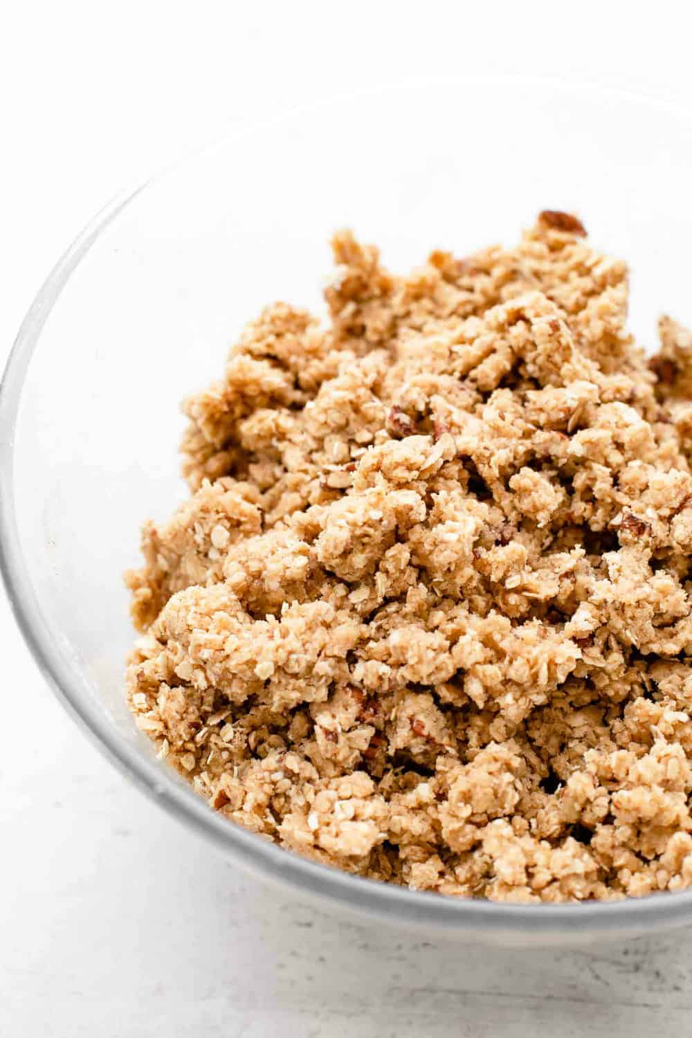 Crumble topping for apple pie bars in a glass mixing bowl