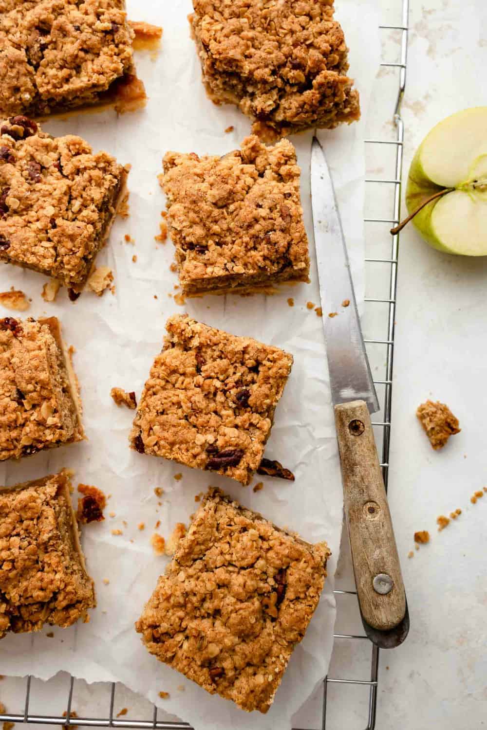 Baked apple pie bars with crumble topping, sliced and on parchment paper