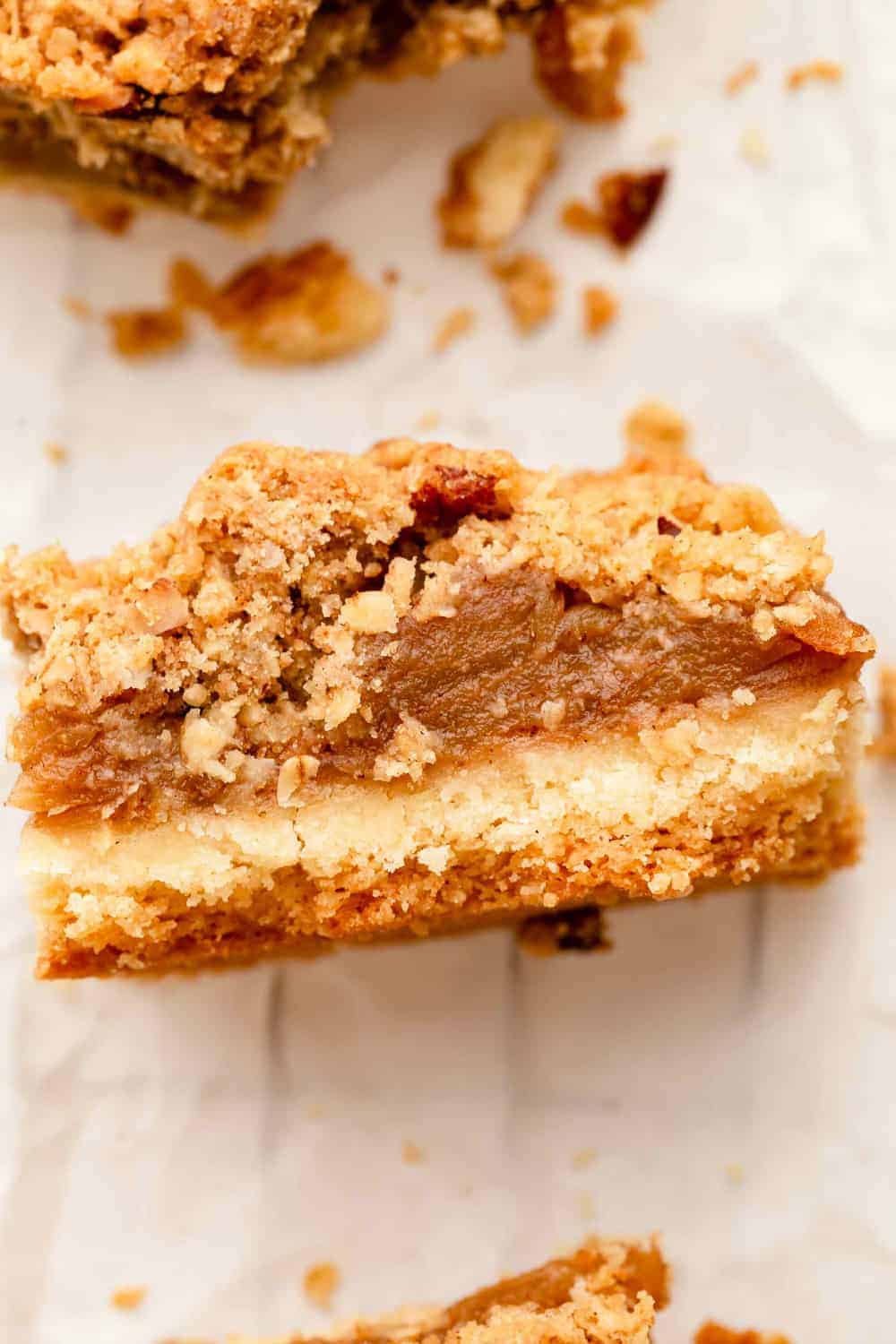 Side view of apple pie bars with shortbread crust and crumble topping