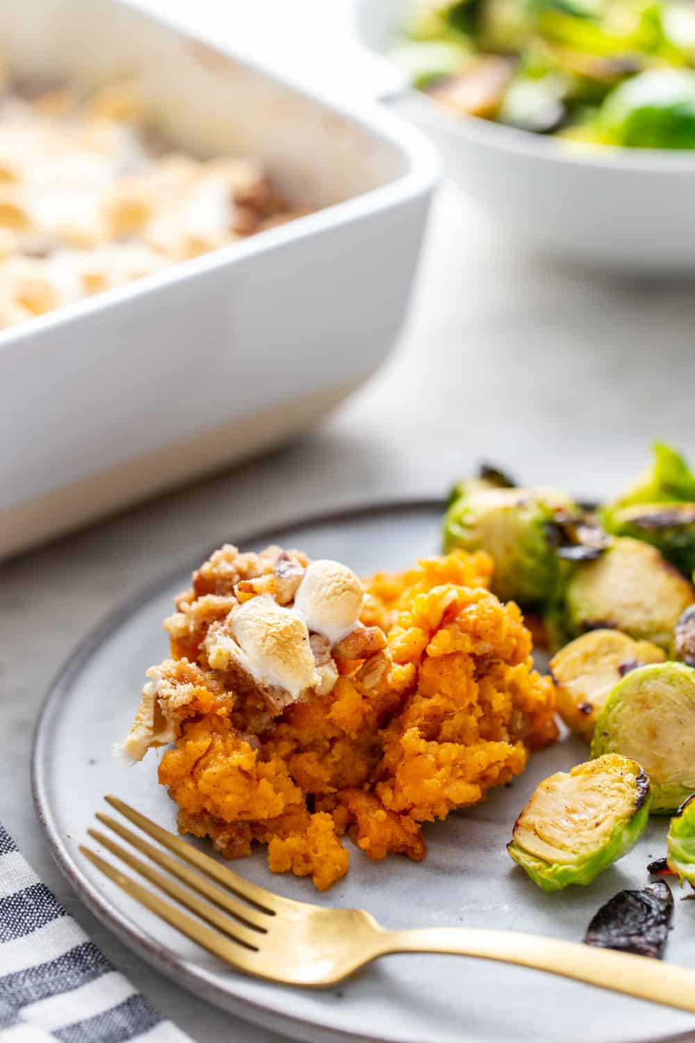 Plated sweet potato casserole next to roasted brussels sprouts