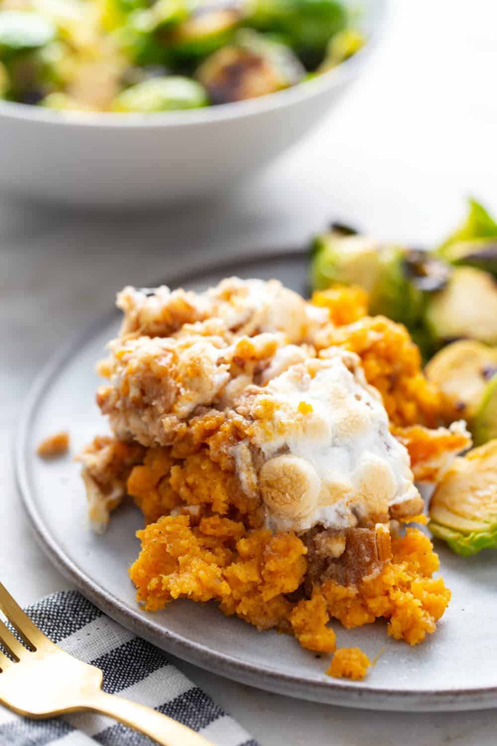 Serving of sweet potato casserole with streusel and marshmallow toppings on a plate
