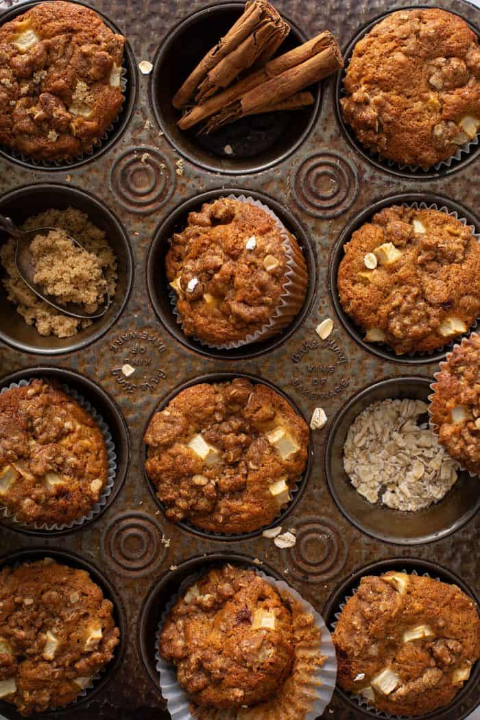 Apple cinnamon muffins arranged in a tarnished muffin tin