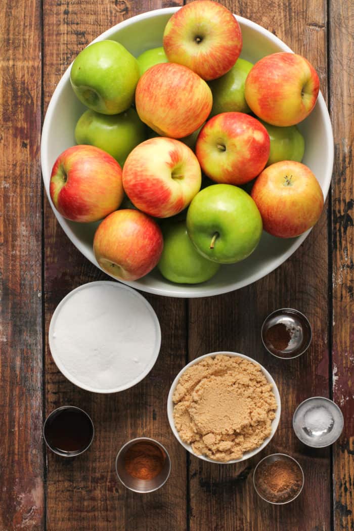 Ingredients for slow cooker apple butter set on a wooden tabletop.