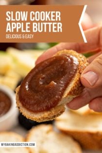 Hand holding up a slice of baguette spread with slow cooker apple butter. Text overlay includes recipe name.