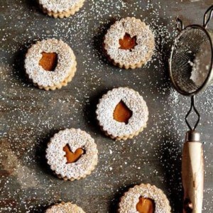 Overhead photo of Linzer cookies with different fall cutouts sprinkled with powdered sugar