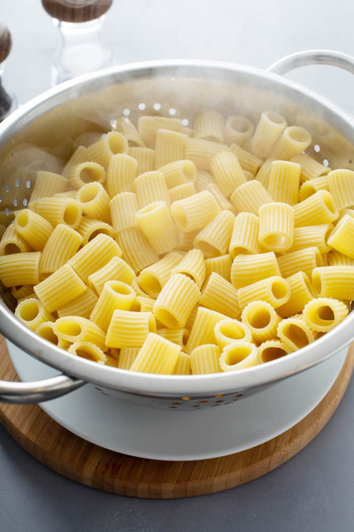 Freshly cooked rigatoni pasta in a colander