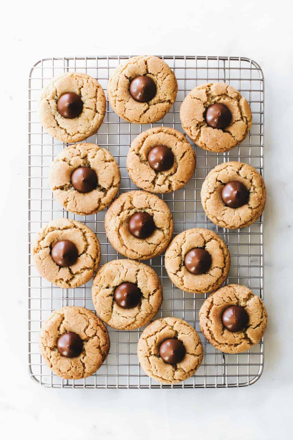 Peanut Butter Blossoms - sometimes known as Hershey Kiss Cookies or Peanut Butter Kiss Cookies - are the perfect classic holiday cookie to make with kids or bring to a cookie exchange.