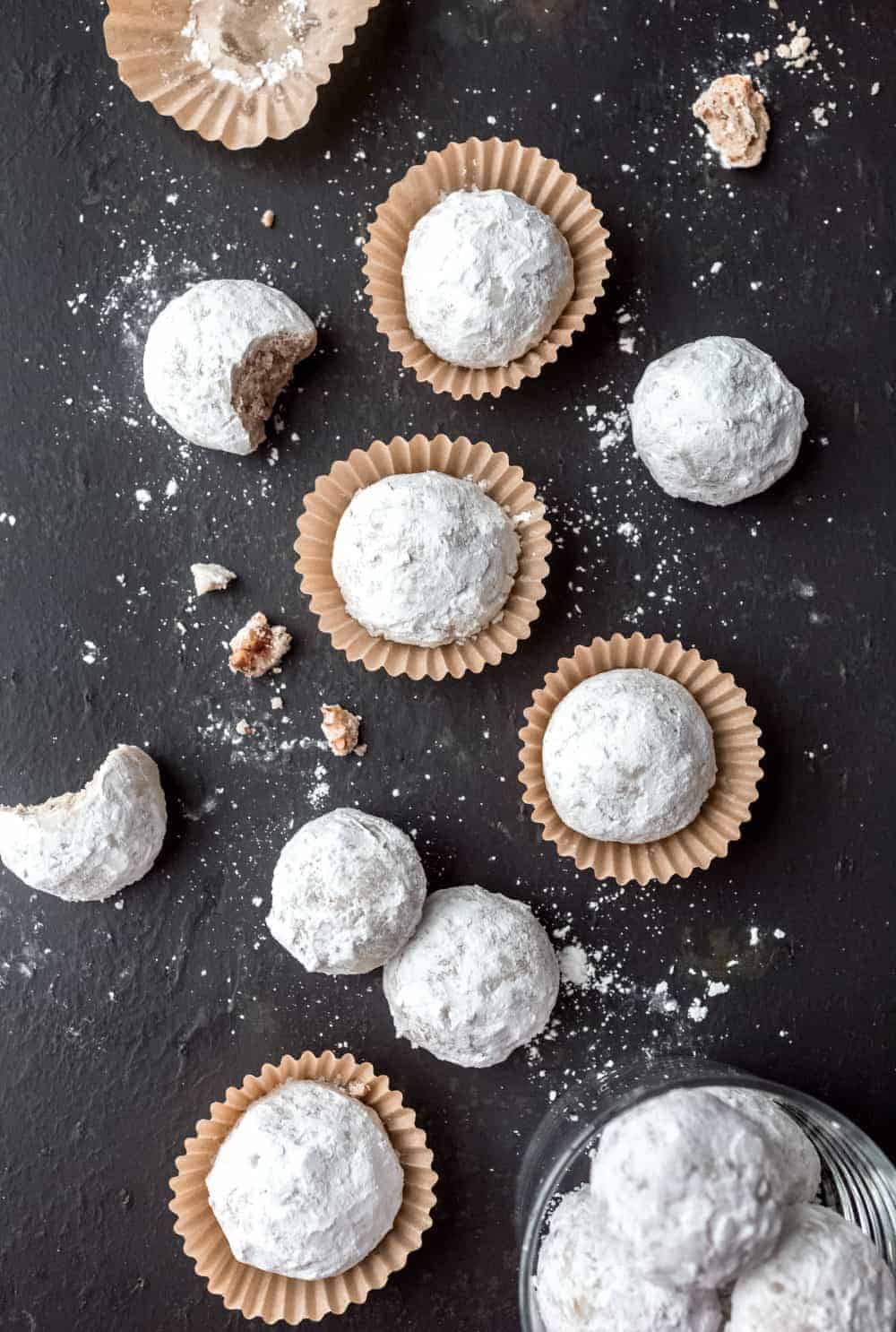 Snowball cookies arranged on a slate surface.