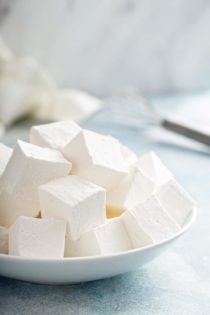 Large white bowl filled with homemade marshmallows on a blue countertop